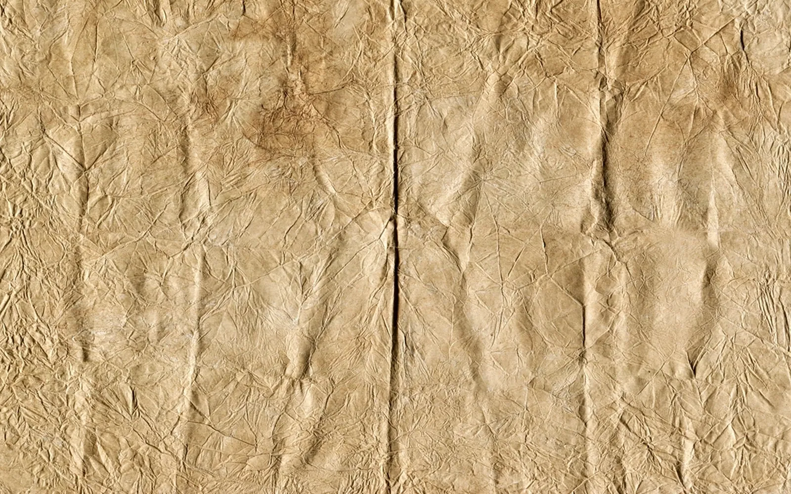 Old sheet of brown paper covered in fine creases and folds