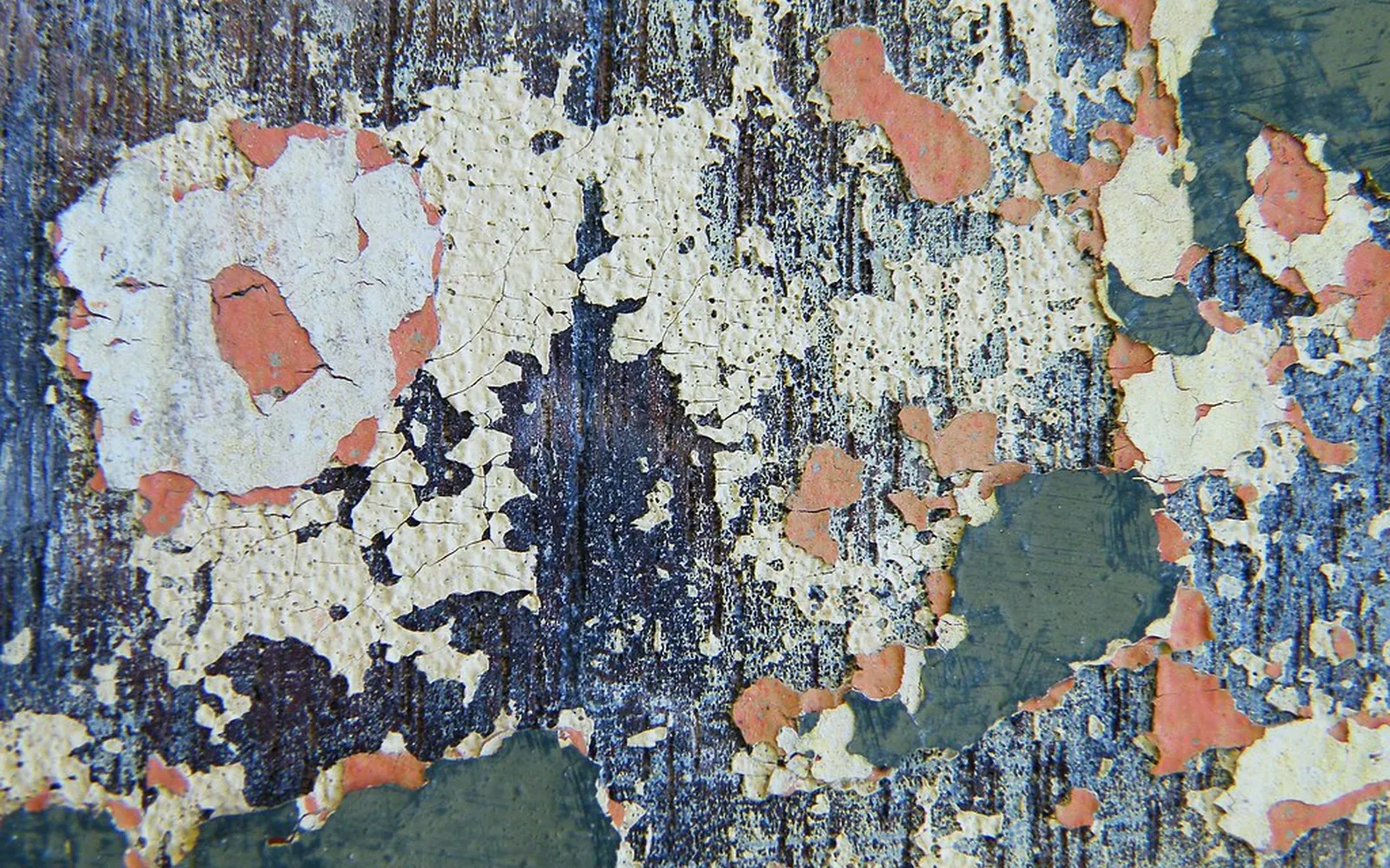 Layers of cream, pink, grey and dark blue paint scraped and flaking to reveal the colours underneath